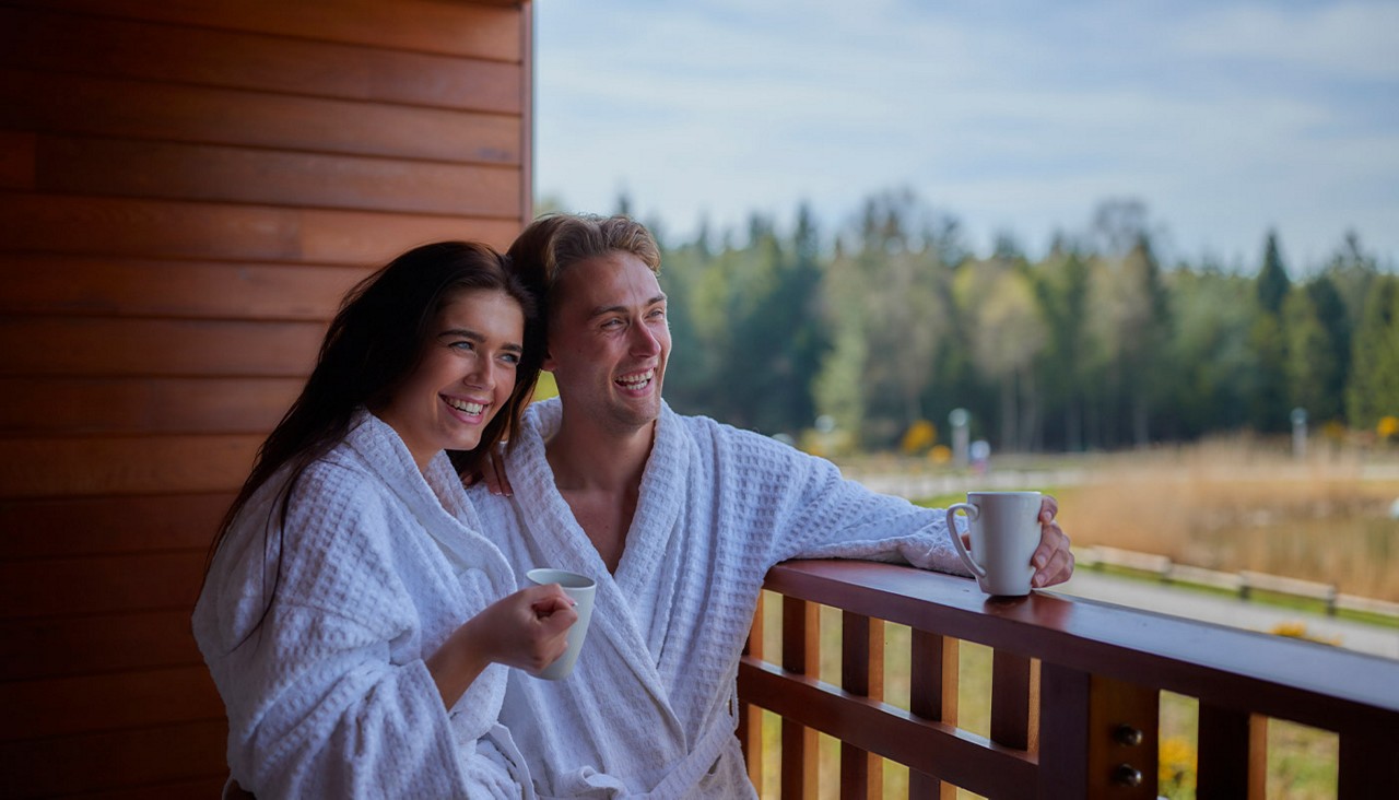 Couple looking out at a lake from their Spa Break Apartment balcony.