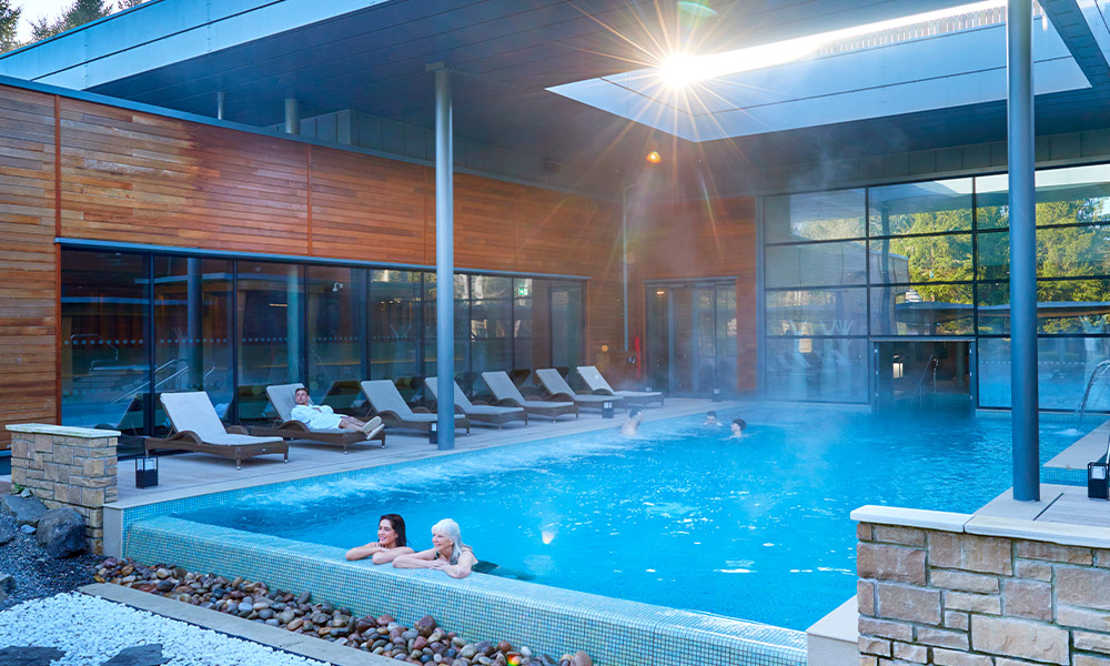 Two women soaking in an outdoor pool.