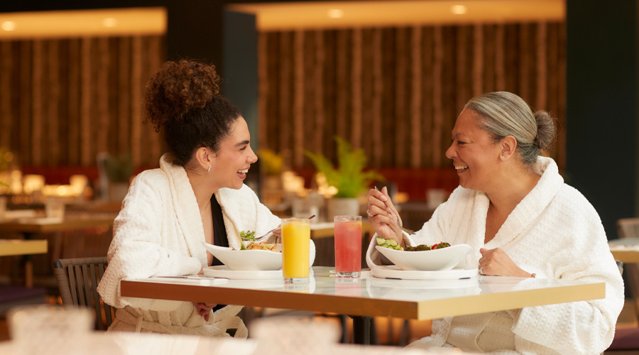 Two women sitting eating and drinking in the Vitalé Café Bar.