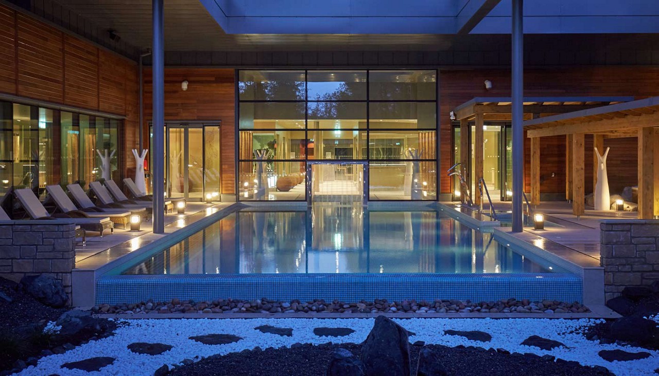 Outdoor pool surrounded by sun loungers.