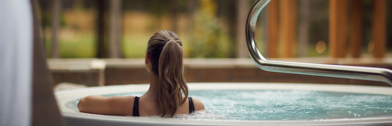 outdoor hot tub with women in with back to camera