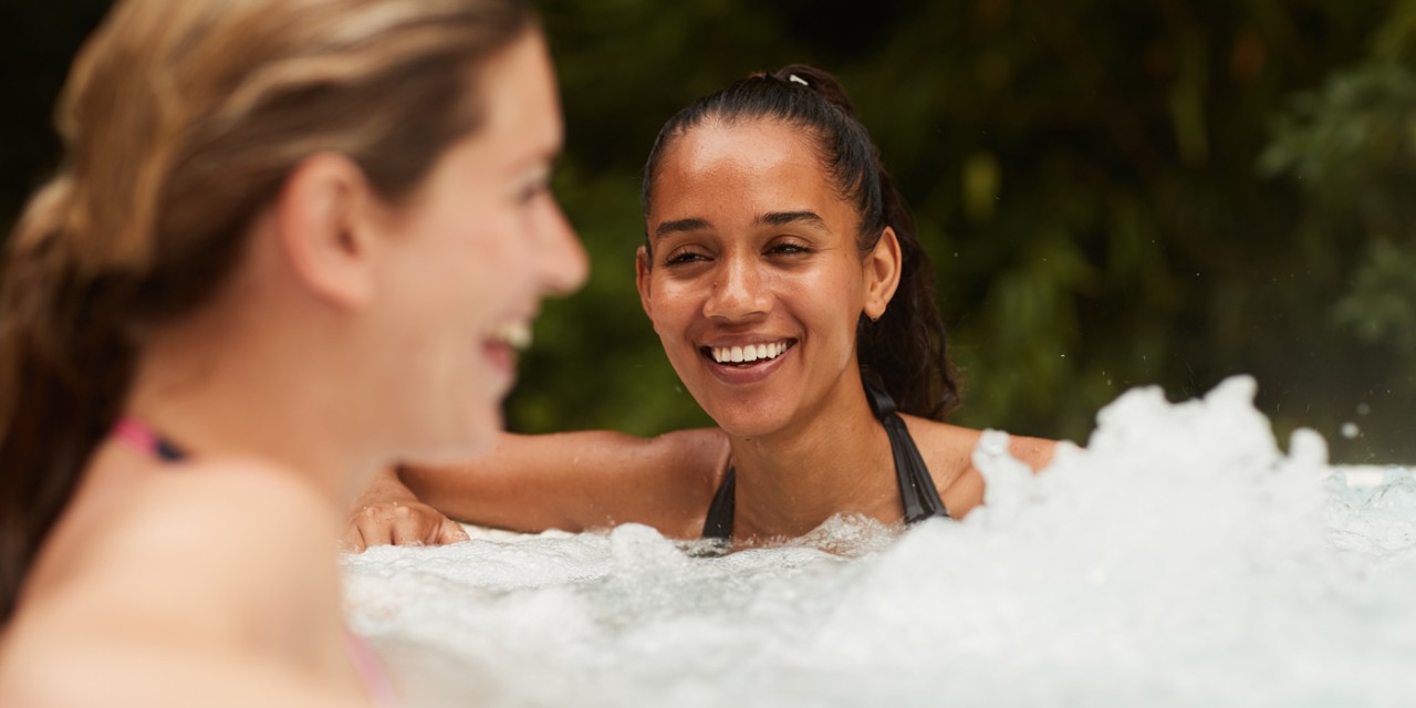 two women in hot tub laughing