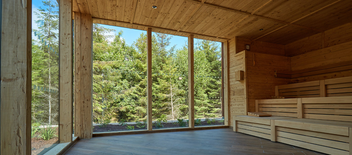 wooden sauna with seats overlooking forest