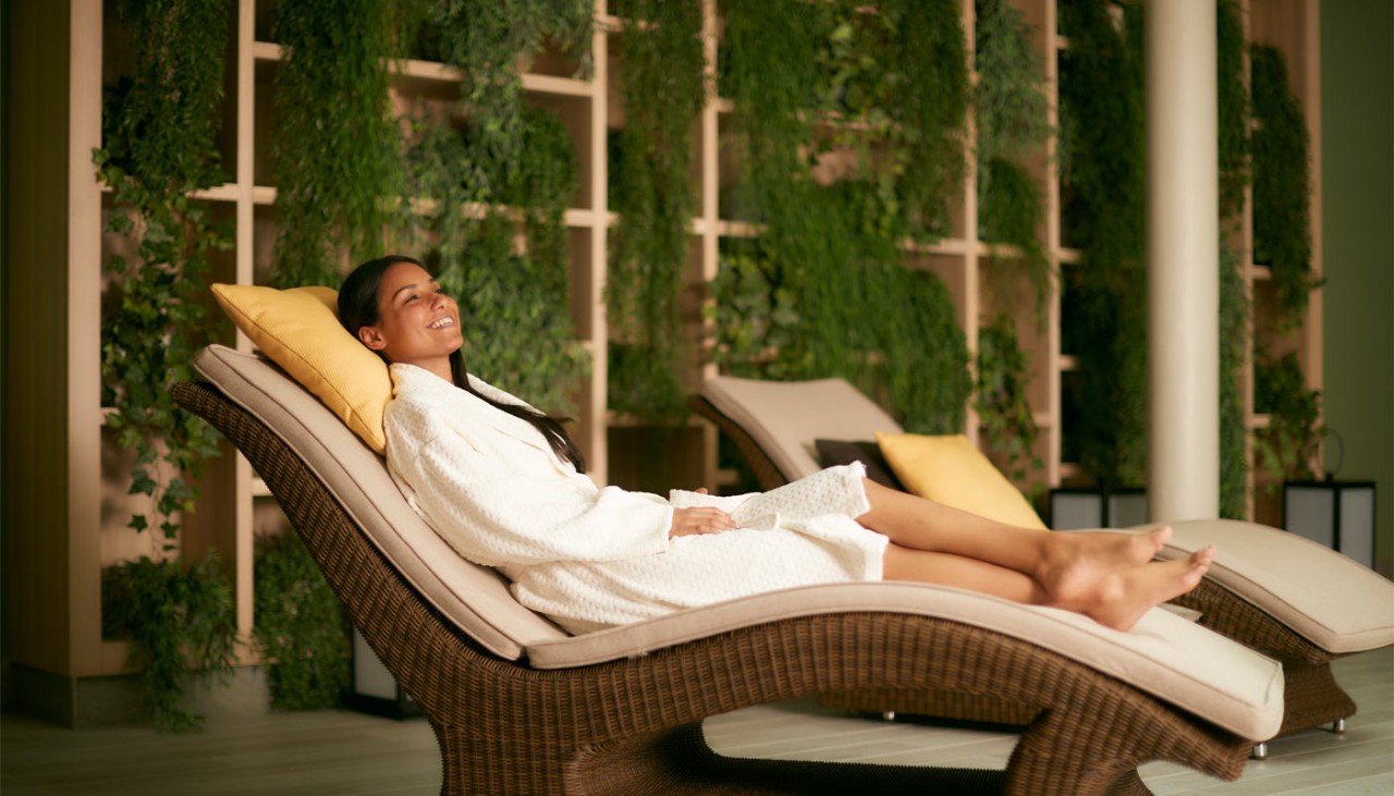 Woman lounging in a spa robe inside Aqua Sana.