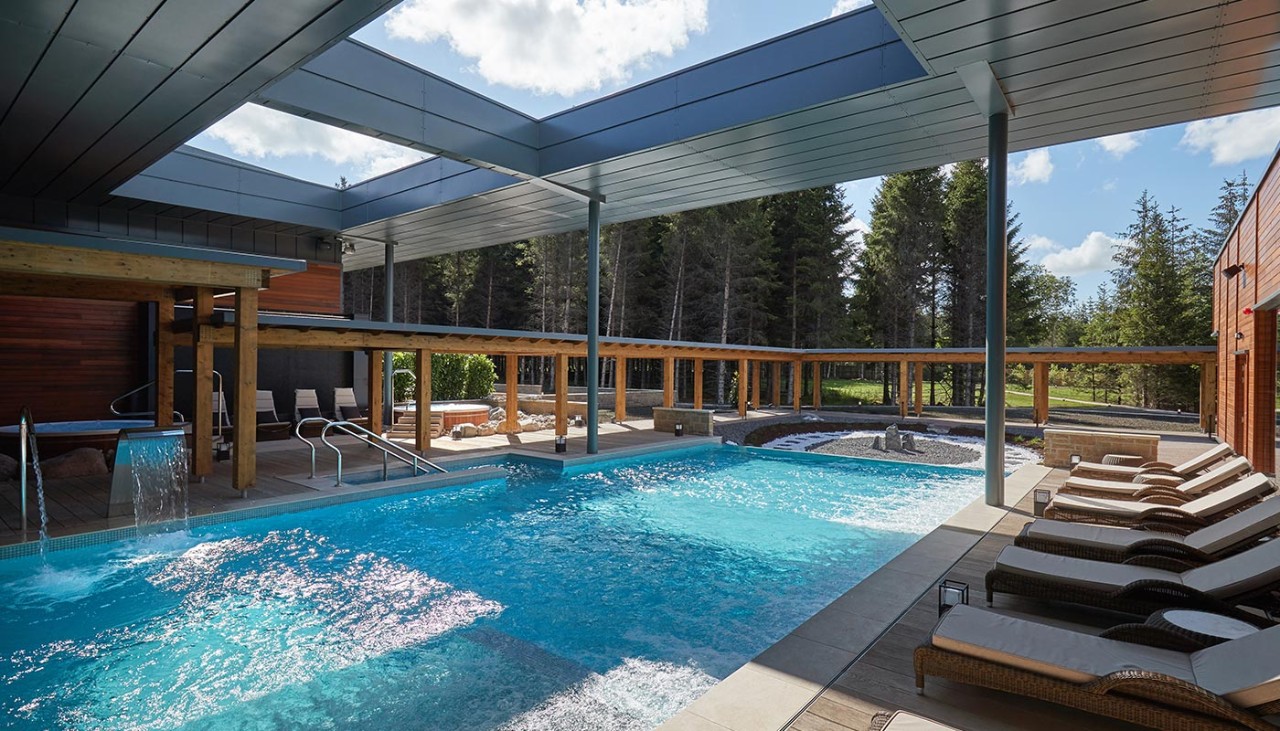 Outdoor pool surrounded by sun loungers.
