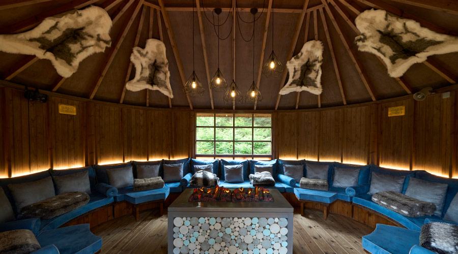 Comfortable seating around a glowing fire in the Scandinavian Snug.