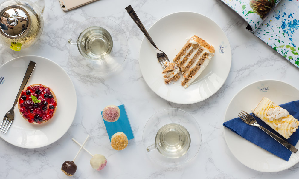 Marble table with a selection of sweet treats and beverages.