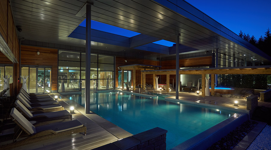 Outdoor pool surrounded by sun loungers.