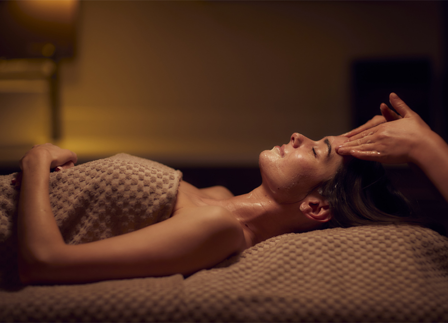 Woman having her head rubbed by a trained spa therapist.