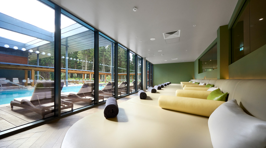 Lounging bed with throw cushions and views out to the outdoor pool.