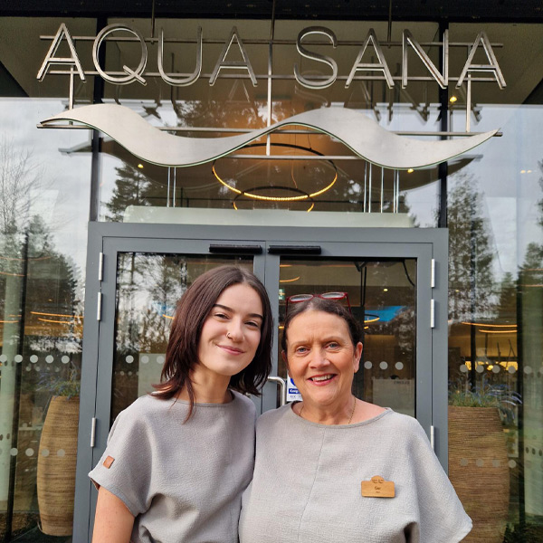 Two Aqua Sana staff members standing in front of the entrance to the spa.