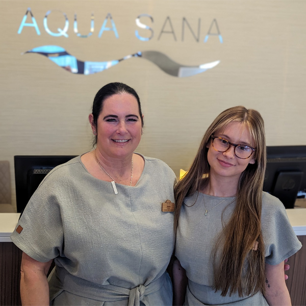 Two Aqua Sana staff members standing in front of the spa reception.