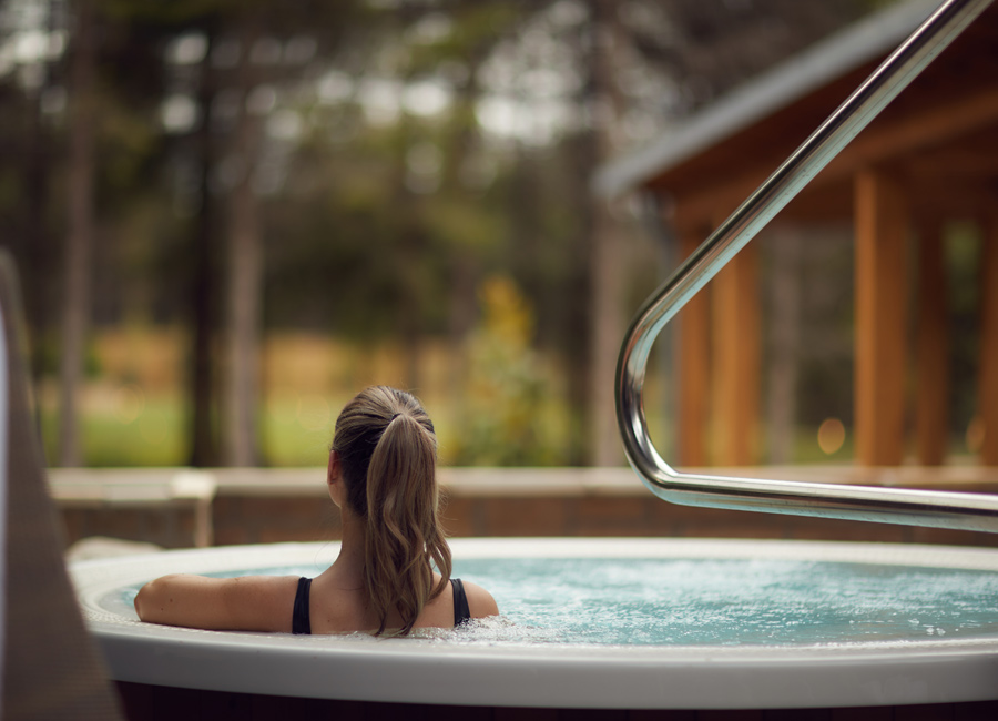 women in outdoor hot tub with back to camera