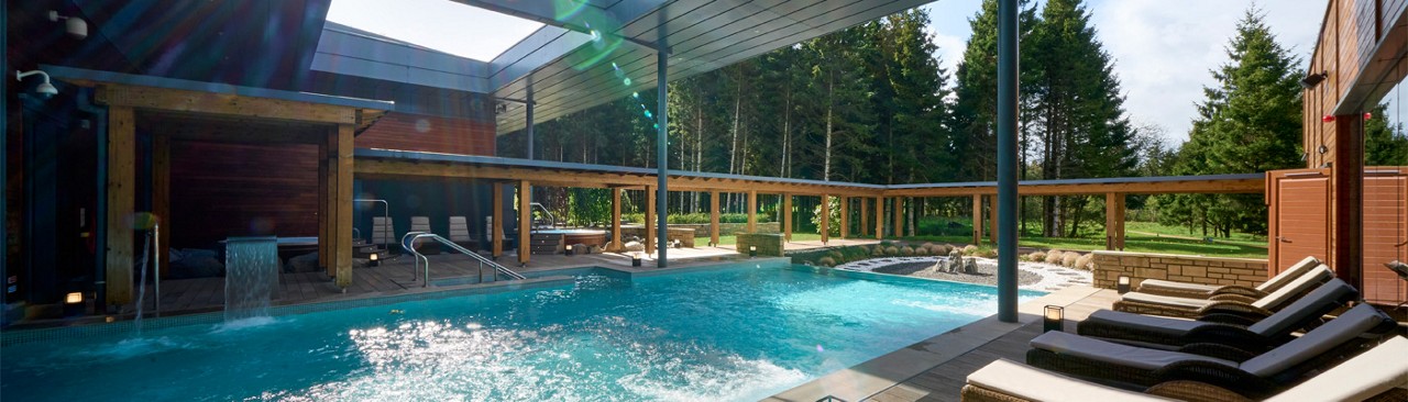 Sun shinning on an Outdoor Pool surrounded by sun loungers.