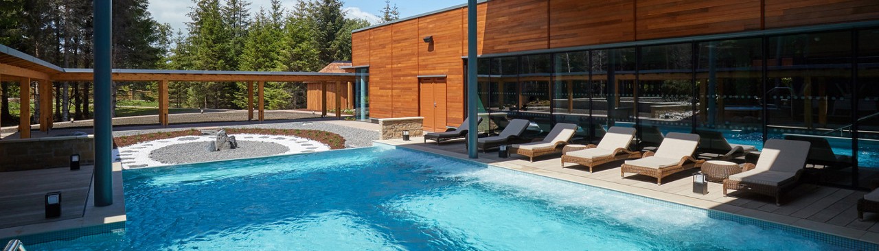 Outdoor pool surrounded by sun loungers.