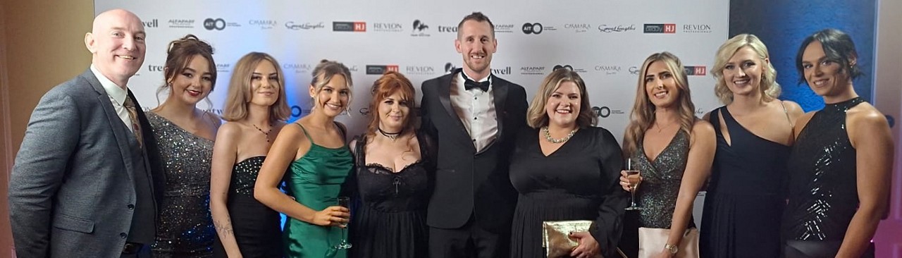 A group stood in evening attire celebrating winning the Spa of the year award.
