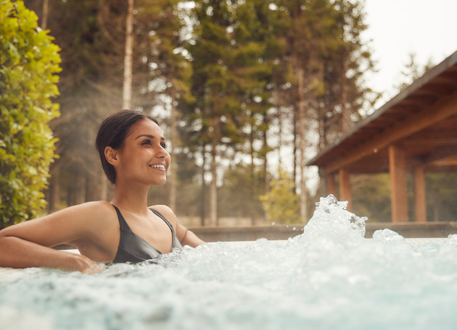Woman soaking in a bubbling outdoor hot tub.