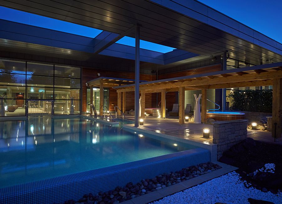 Outdoor pool surrounded by glowing lights.