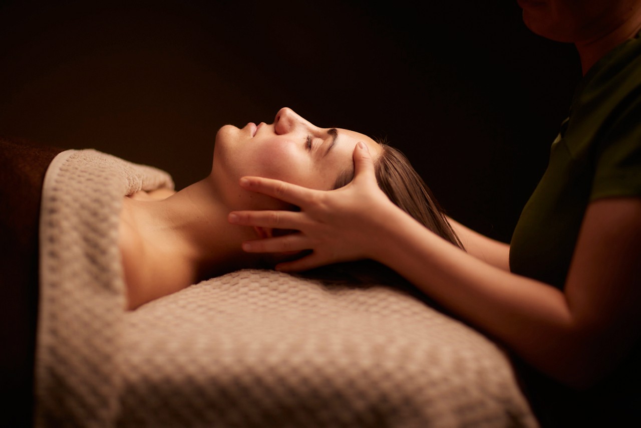 Woman having her head rubbed by a trained spa therapist.