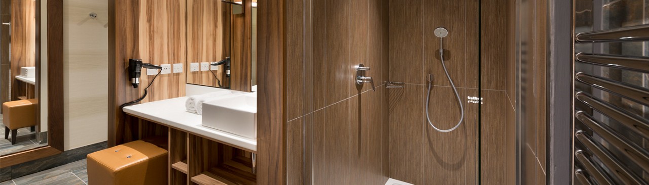 bathroom with shower, sink and mirror