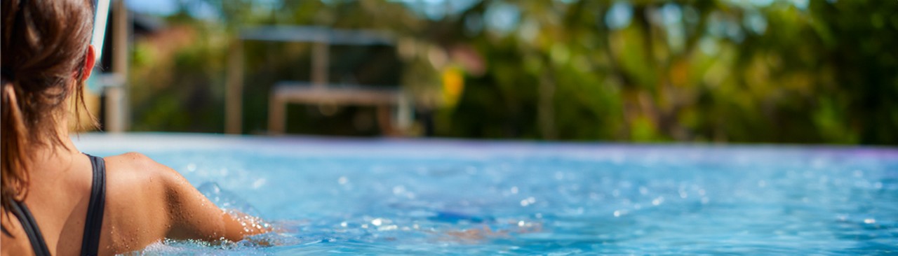 Woman soaking in a bubbling hot tub surrounded by the forest.