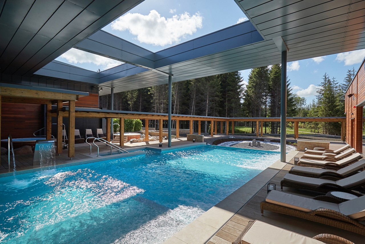 The sun reflecting on an Outdoor Pool surrounded by sun loungers.