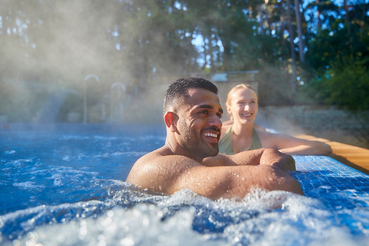 Two people smiling in a hot tub