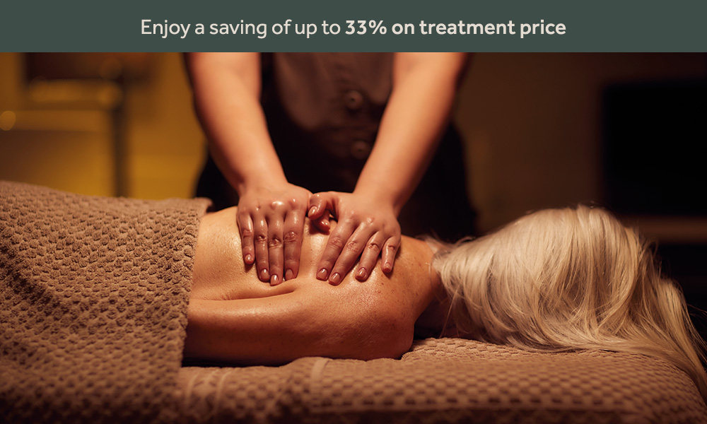 A spa therapist massaging a ladies back