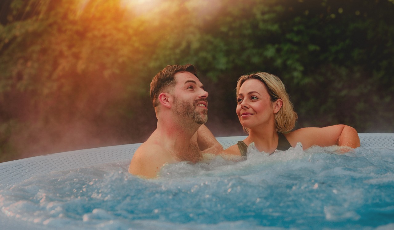 Two people smiling in a hot tub