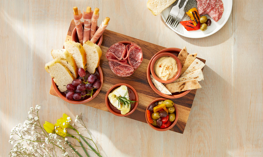 Grazing platter with deli meat, Italian breads, olives and a selection of dips.