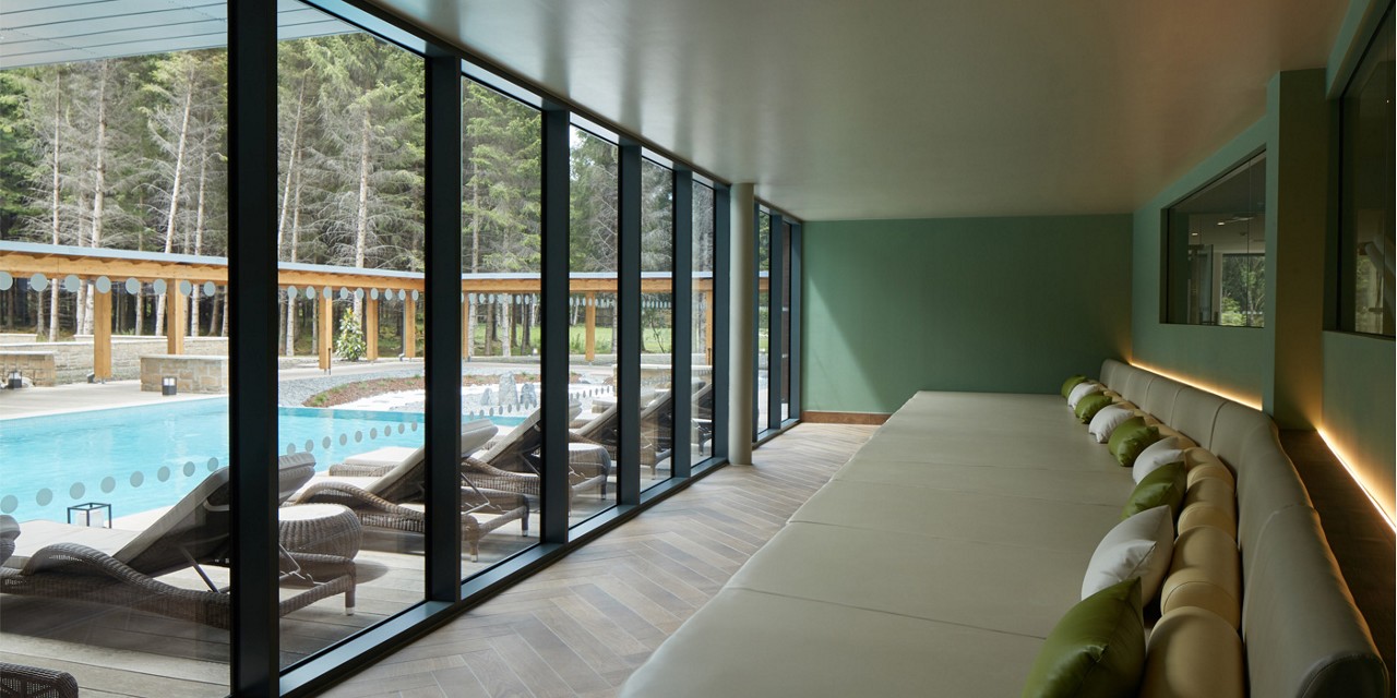 relax area with large sofa overlooking outdoor pool
