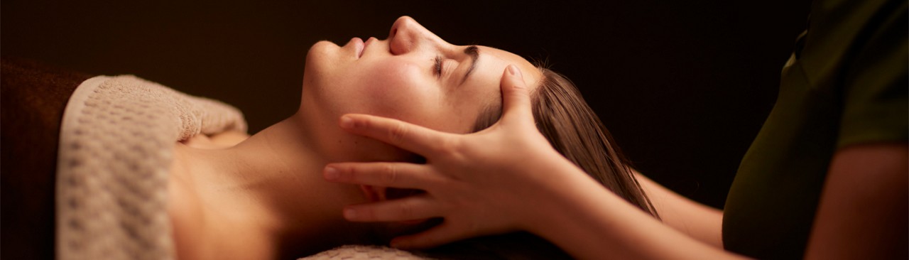 Spa therapist giving a woman a relaxing face and body treatment.