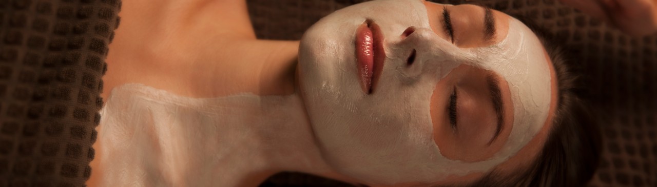 woman laid with eyes closed with facial on