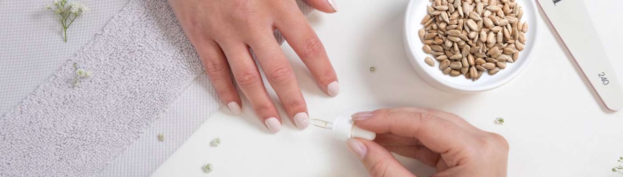 painted fingernails with cuticle oil being applied
