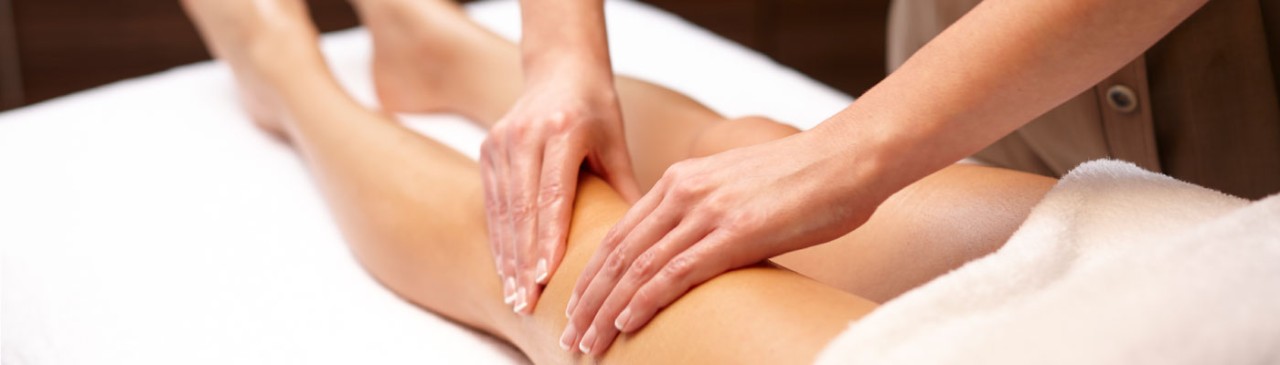 woman receiving body massage on leg