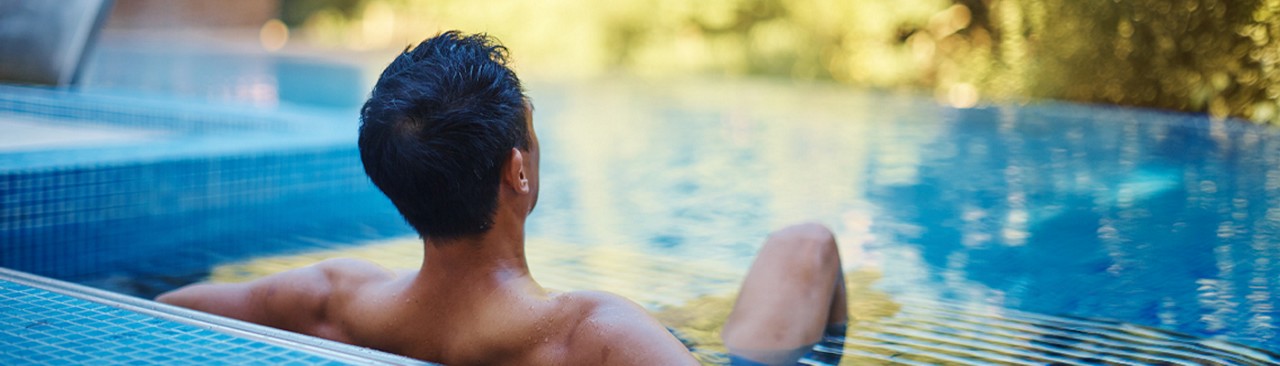 man and woman leaning on side of pool