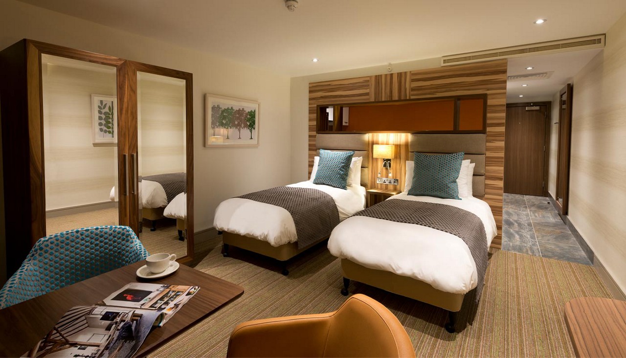 Twin bedroom with a small living space and a separate kitchen area. 