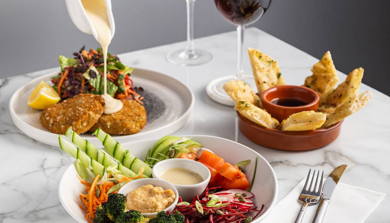 Fishcakes, salad and bread served with a dipping sauce.