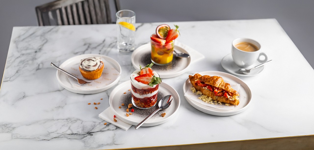 Breakfast items including sweet and savoury croissants and a granola pot.