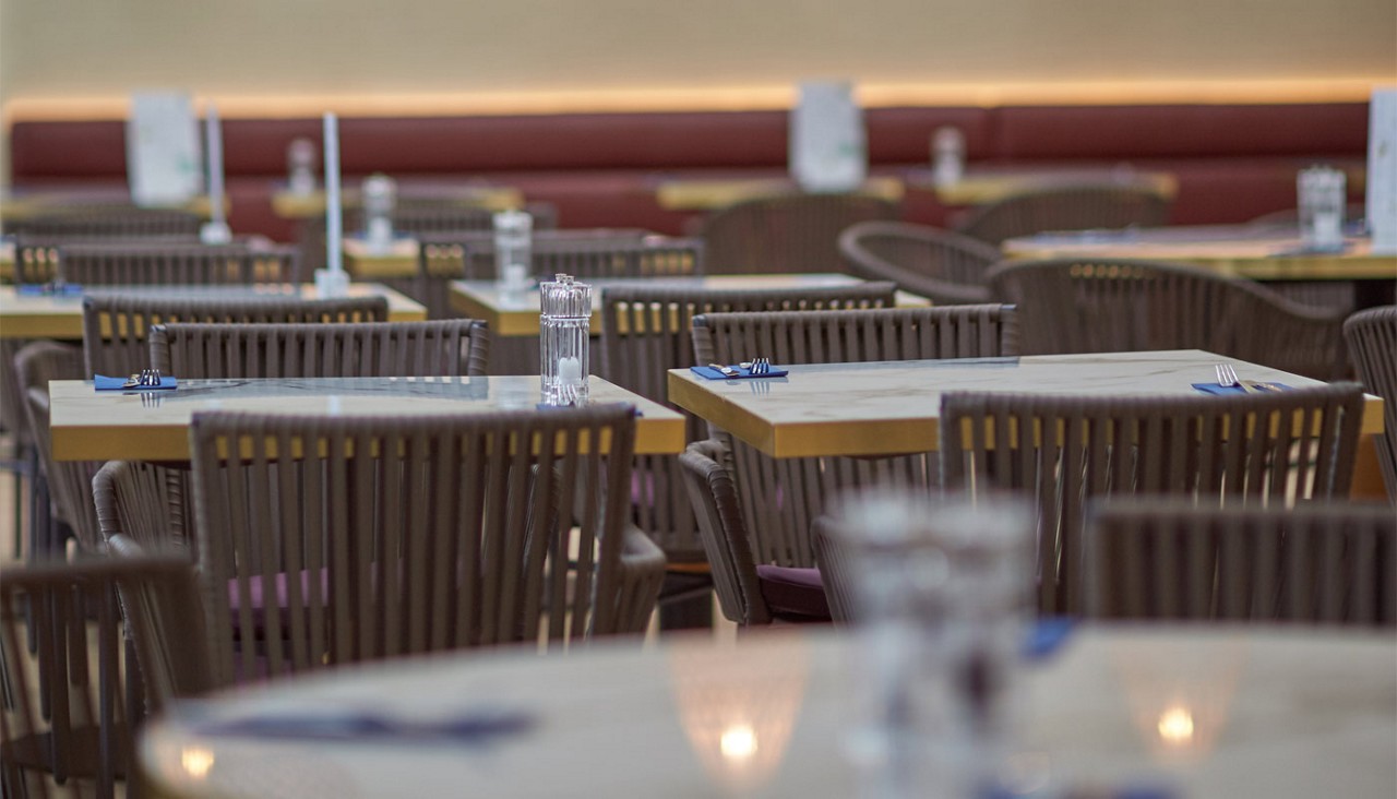 Close up image of the tables and chairs laid out with candles and glasses of water.